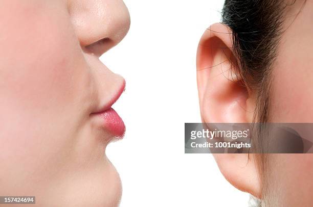 whispering - ear stockfoto's en -beelden