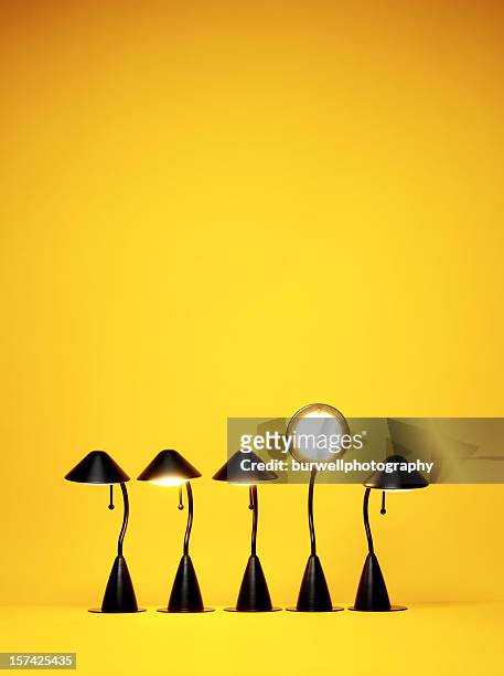 bright idea, five desk lamps against yellow - standing out from the crowd stock pictures, royalty-free photos & images
