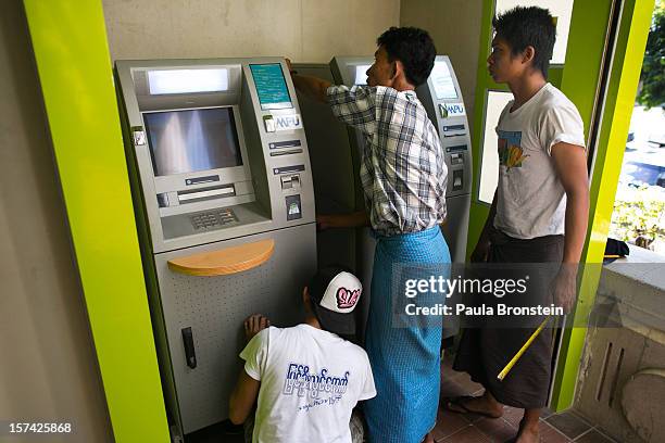 New ATM bank machine is installed, simplifying the access to Kyat, the local Burmese currency, on November 30, 2012 in downtown Yangon, Myanmar....