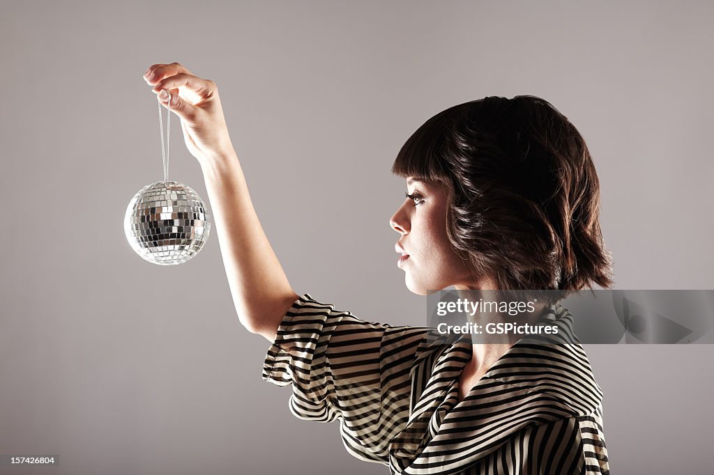 Profile of woman looking at small disco ball