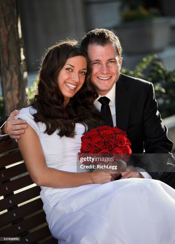 Bride and Groom Sitting on Bench