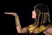 Person portraying Cleopatra on black background