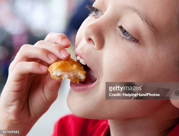 boy eating chicken nugget - deep fry stock pictures, royalty-free photos & images