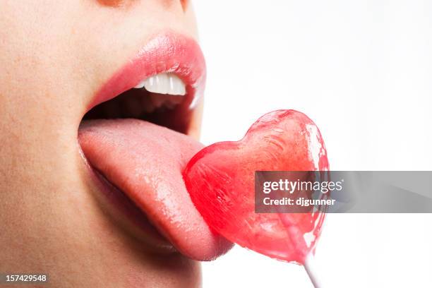 girl licks heart lollipop - candy on tongue stock pictures, royalty-free photos & images