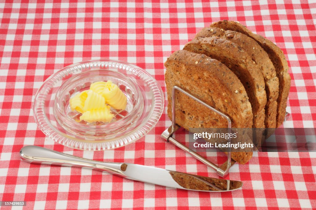 Wholemeal brinde, manteiga e faca em tecido Guingão