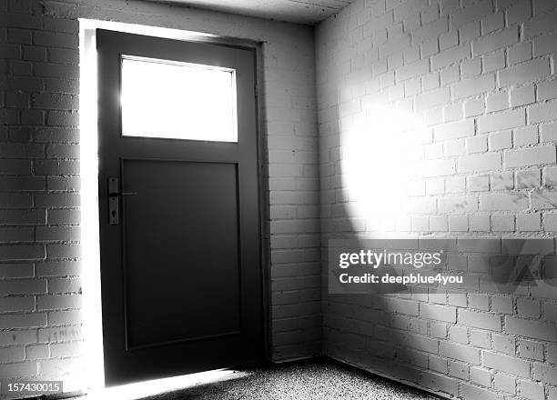 light behind door with window in empty basemant room - cellar stockfoto's en -beelden