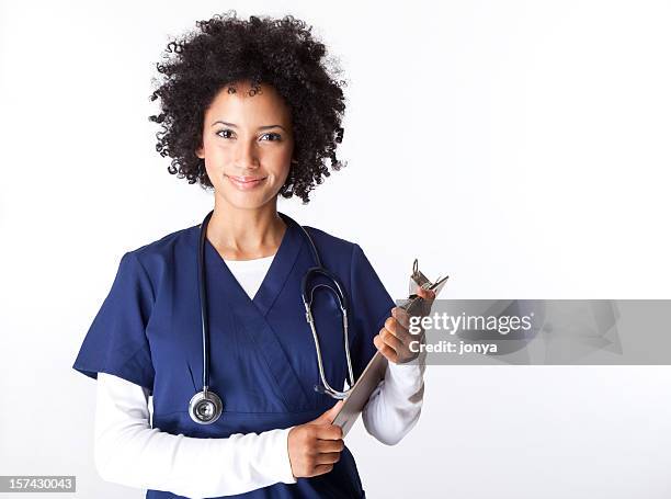 pretty female nurse with curly hair holding clipboard - female nurse stockfoto's en -beelden