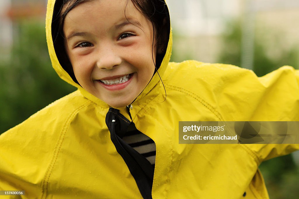 Happy young girl with a rain coat