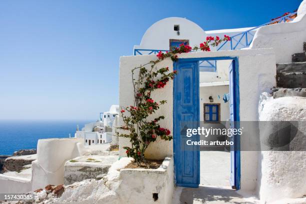 wide open blue door and bougainvillea - santorini stockfoto's en -beelden