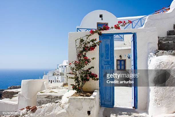 wide open blue door and bougainvillea - blue house red door stock pictures, royalty-free photos & images