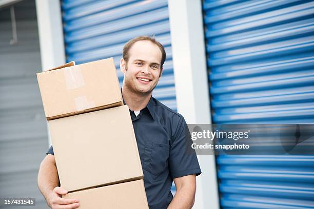 hombre con cajas móviles en el almacenamiento de la empresa - self storage fotografías e imágenes de stock