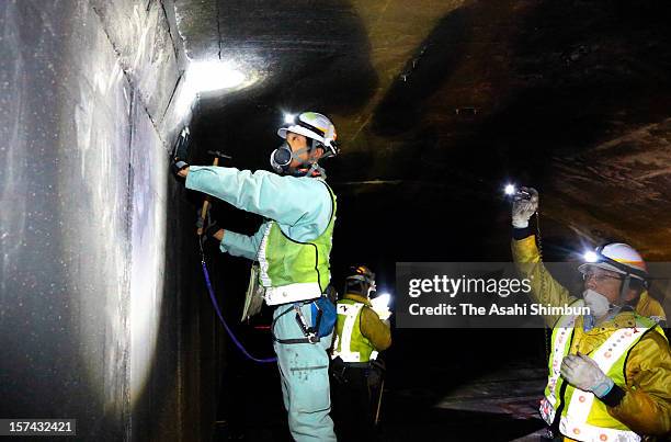 Workers operate emergency safety check by hitting the concrete ceiling with hummer at Enasan tunnel, same stracture as collapsed Sasago tunnel on...