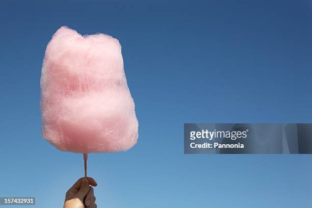 pink cotton candy being held up against a clear blue sky - cotton candy stock pictures, royalty-free photos & images