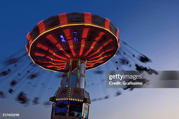 blurred motion of merry-go-round chairoplane at night - carousel swings stock pictures, royalty-free photos & images