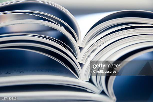 stack of open magazines - book blue stockfoto's en -beelden