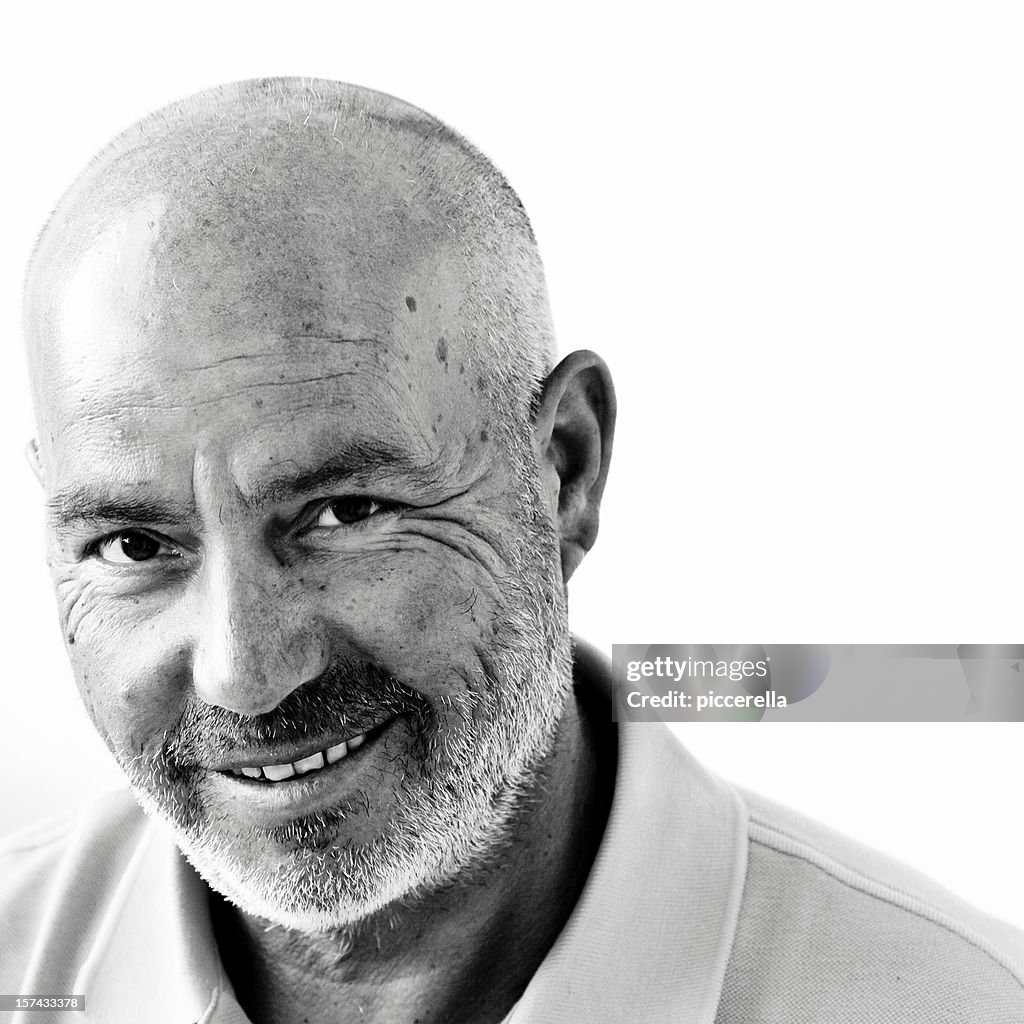 A wise bald happy man posing for a photo