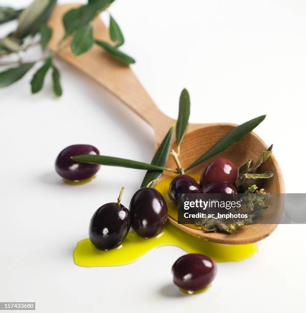 olives noires sur une louche en bois - olive oil photos et images de collection