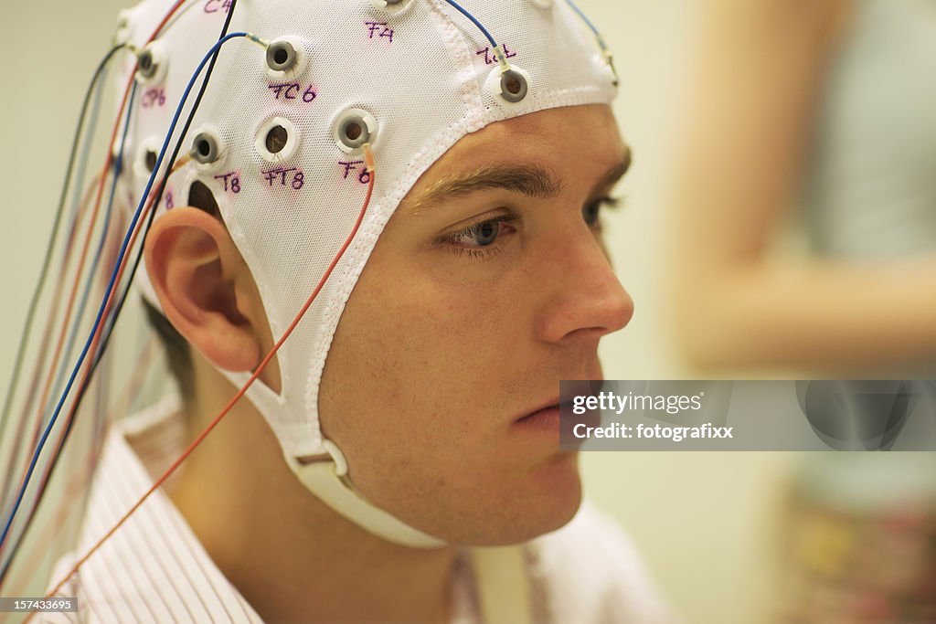 Man connected with cables to computer - EEG for resarch