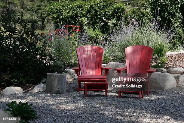 red adirondack chairs and blue russian sage in the garden - plastic adirondack chair stock pictures, royalty-free photos & images