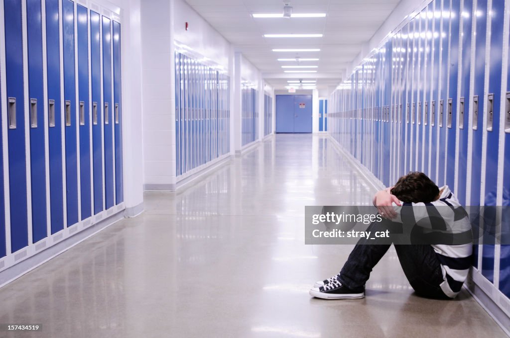 Depressed Boy in School Hallway