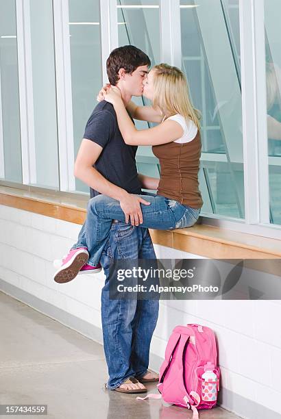 high school dating and romance, kissing in a hallway - couple school stockfoto's en -beelden