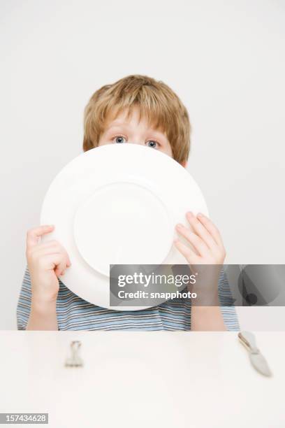 child boy with knife and fork licking dinner plate - licking stock pictures, royalty-free photos & images