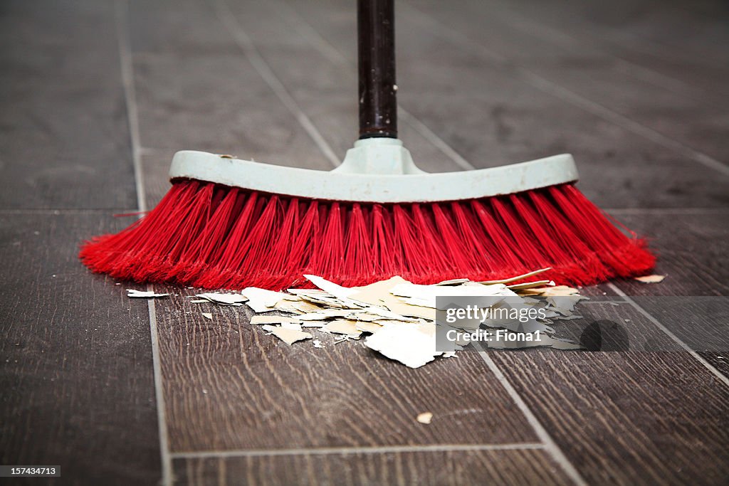 Sweeping the wooden floor with a broom