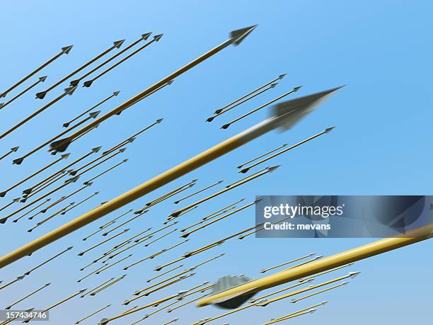 many blurred arrows in motion flying through clear blue sky - archer stock pictures, royalty-free photos & images