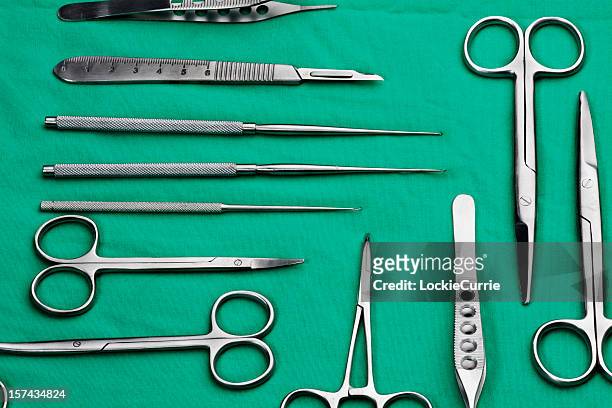 silver surgical instruments on a green tray - surgery tools stock pictures, royalty-free photos & images