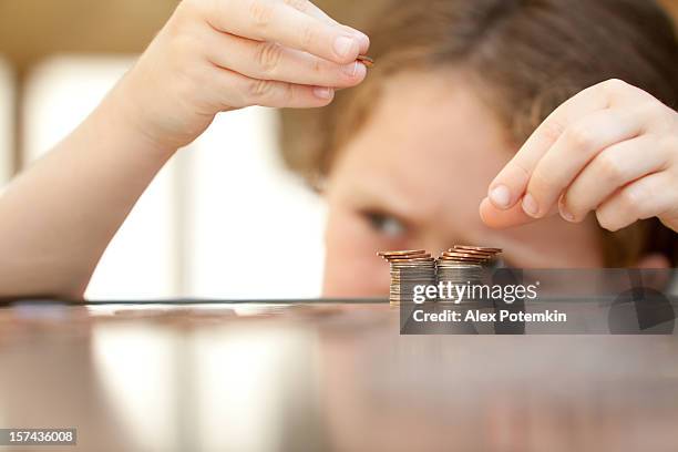 young girl stacking coins on a tabletop - allowance bildbanksfoton och bilder