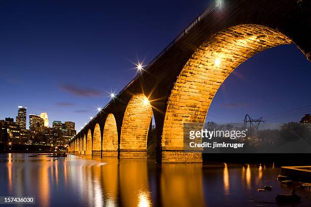 minneapolis' famous stone arch bridge and mississippi river. - minneapolis downtown stock pictures, royalty-free photos & images