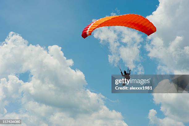 a man paragliding in the blue sky - paragliding stock pictures, royalty-free photos & images