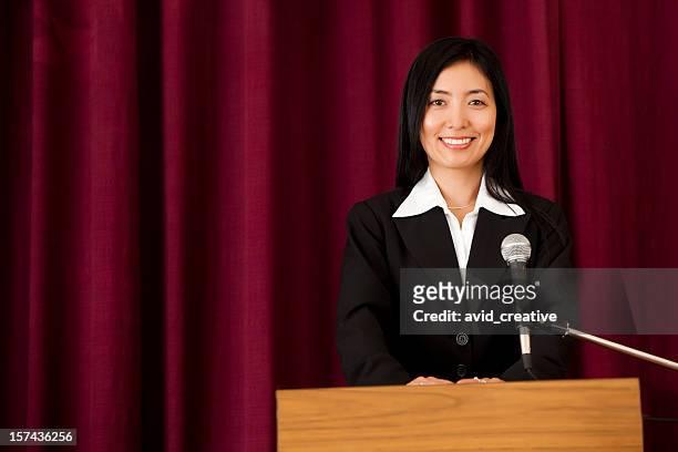 smiling asian woman at podium - awards gala press room stock pictures, royalty-free photos & images
