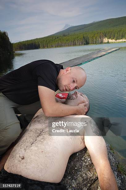 cpr on drowning victim beside mountain lake - survival kit stock pictures, royalty-free photos & images