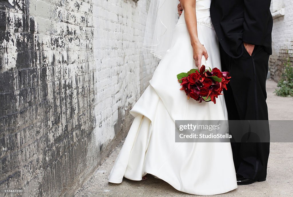 Bride and Groom in alley, Red bouquet