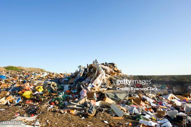 large pile of garbage at a landfill with blue sky. - rubbish stock pictures, royalty-free photos & images