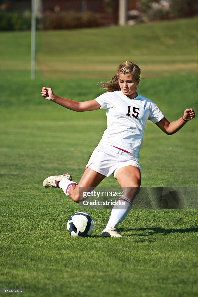 Female Soccer Player in White Power Kicks with copyspace