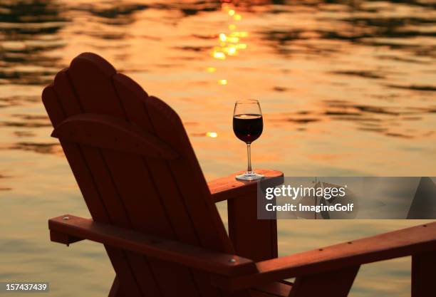 adirondack chair and wine at sunset by lake - british columbia beach stock pictures, royalty-free photos & images