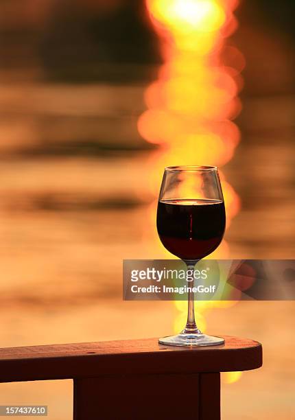 glass of red wine - adirondack chair closeup stock pictures, royalty-free photos & images