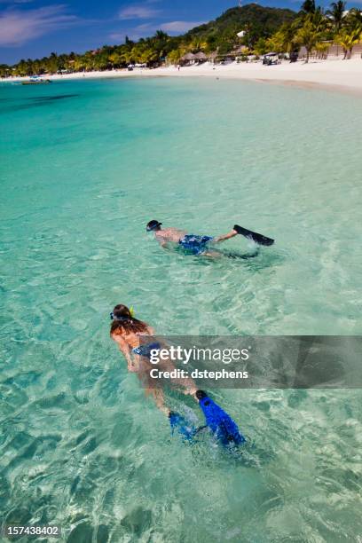 pareja buceo con esnórkel desde la playa tropical - honduras fotografías e imágenes de stock