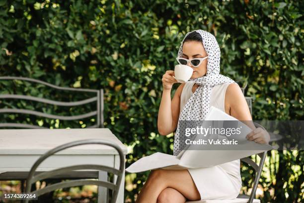 drinking morning coffee with a newspaper in yard - vintage crockery stock pictures, royalty-free photos & images