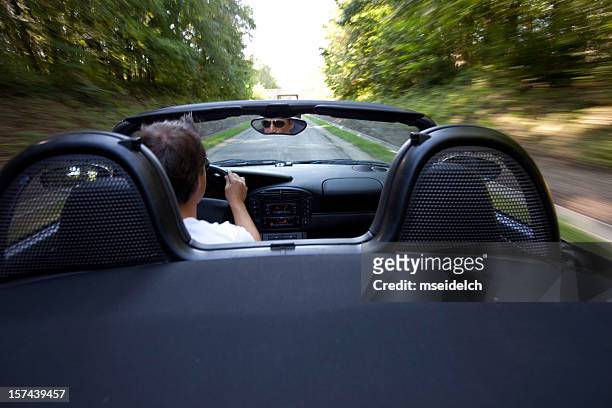 outside view of a man in convertible speeding down the road - sports car interior stock pictures, royalty-free photos & images