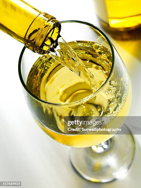 pouring white wine - chardonnay grape 個照片及圖片檔