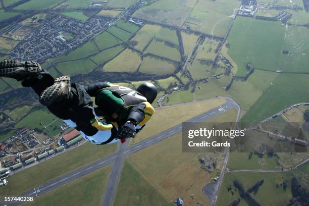 skydiver free falling above countryside - skydiving stock pictures, royalty-free photos & images