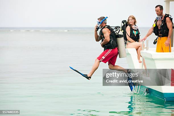 vacation lifestyles-scuba diver jumping off boat - scuba diving stock pictures, royalty-free photos & images