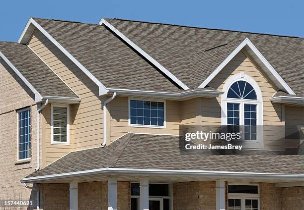 new residential house; architectural asphalt shingle roof, vinyl siding - dakgoot stockfoto's en -beelden