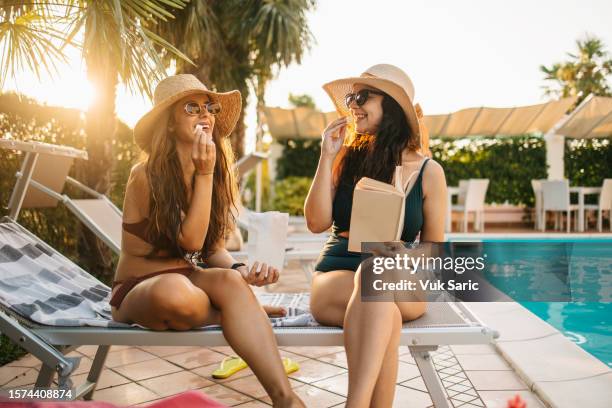 sitting on a sunbed by the pool - ao lado da piscina imagens e fotografias de stock