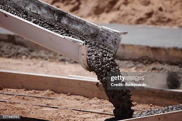 cement pouring from a mixer truck chute - spilling stock pictures, royalty-free photos & images