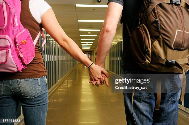 high school couple holding hands from behind - teenage romance stock pictures, royalty-free photos & images