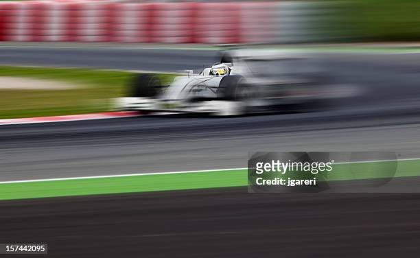 an open-wheel race car in motion - nascar track stock pictures, royalty-free photos & images
